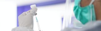 Syringe and vial with masked person