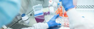 person pipetting in a medical lab